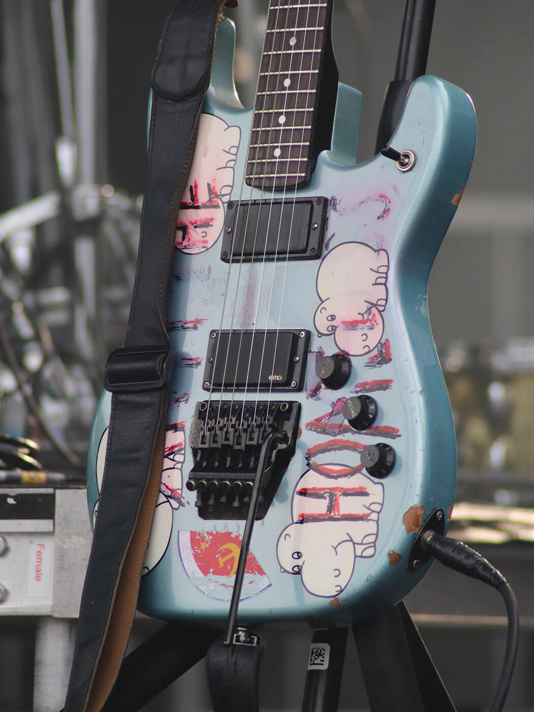 Blue Tom Morello “Arm The Homeless” guitar with decals in a studio