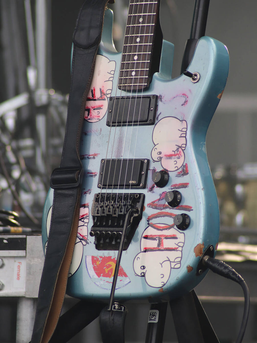 Blue Tom Morello “Arm The Homeless” guitar with decals in a studio