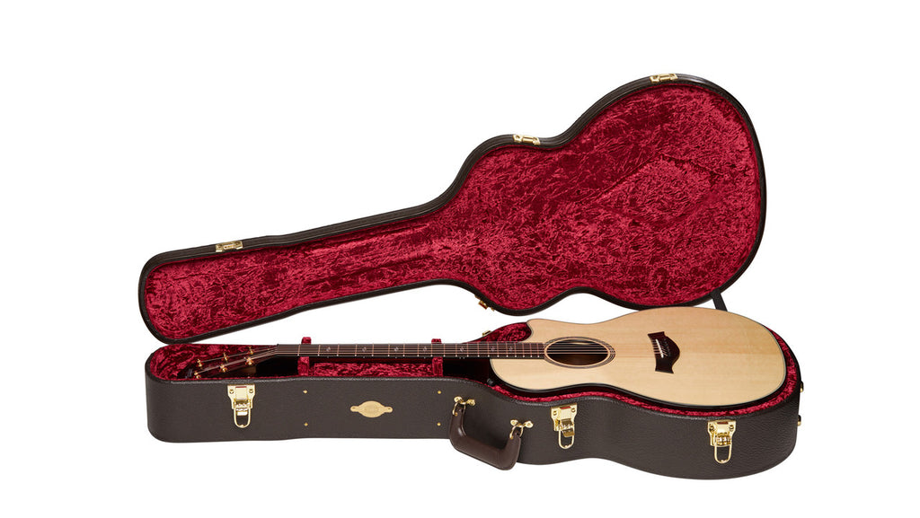 Open Taylor case with a Grand Auditorium guitar resting in the red crushed velvet interior