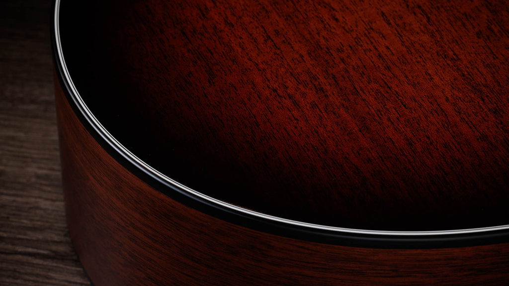 Black binding meeting the satin mahogany top on the lower bout edge