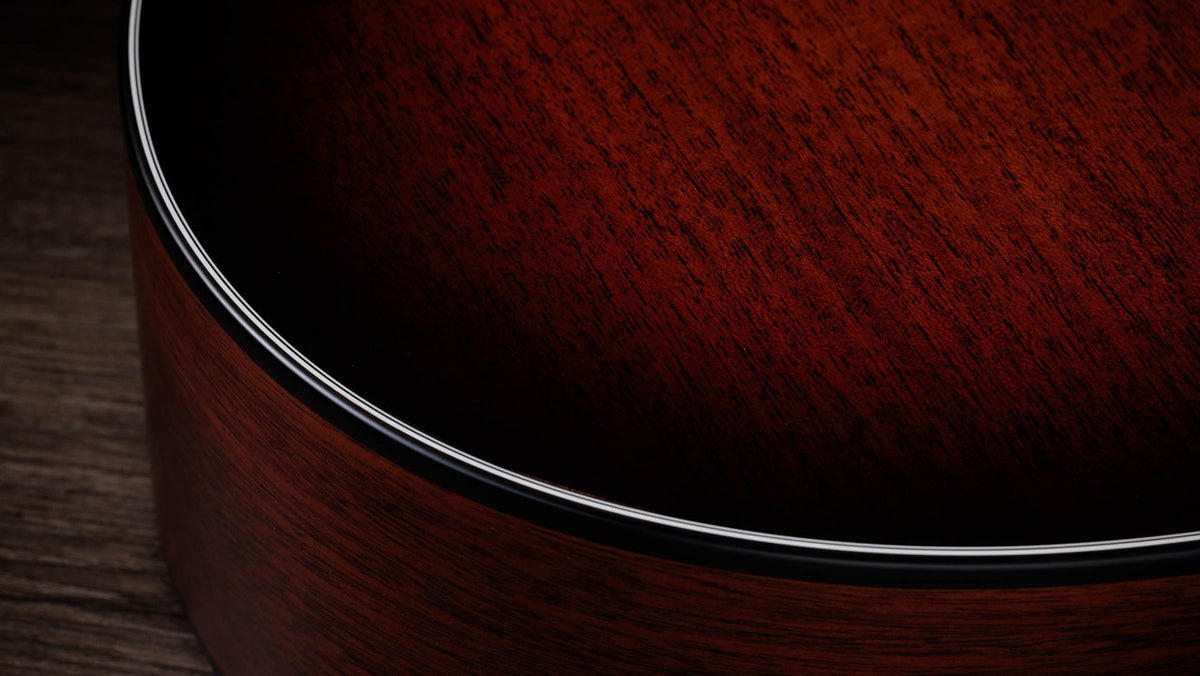 Black binding meeting the satin mahogany top on the lower bout edge