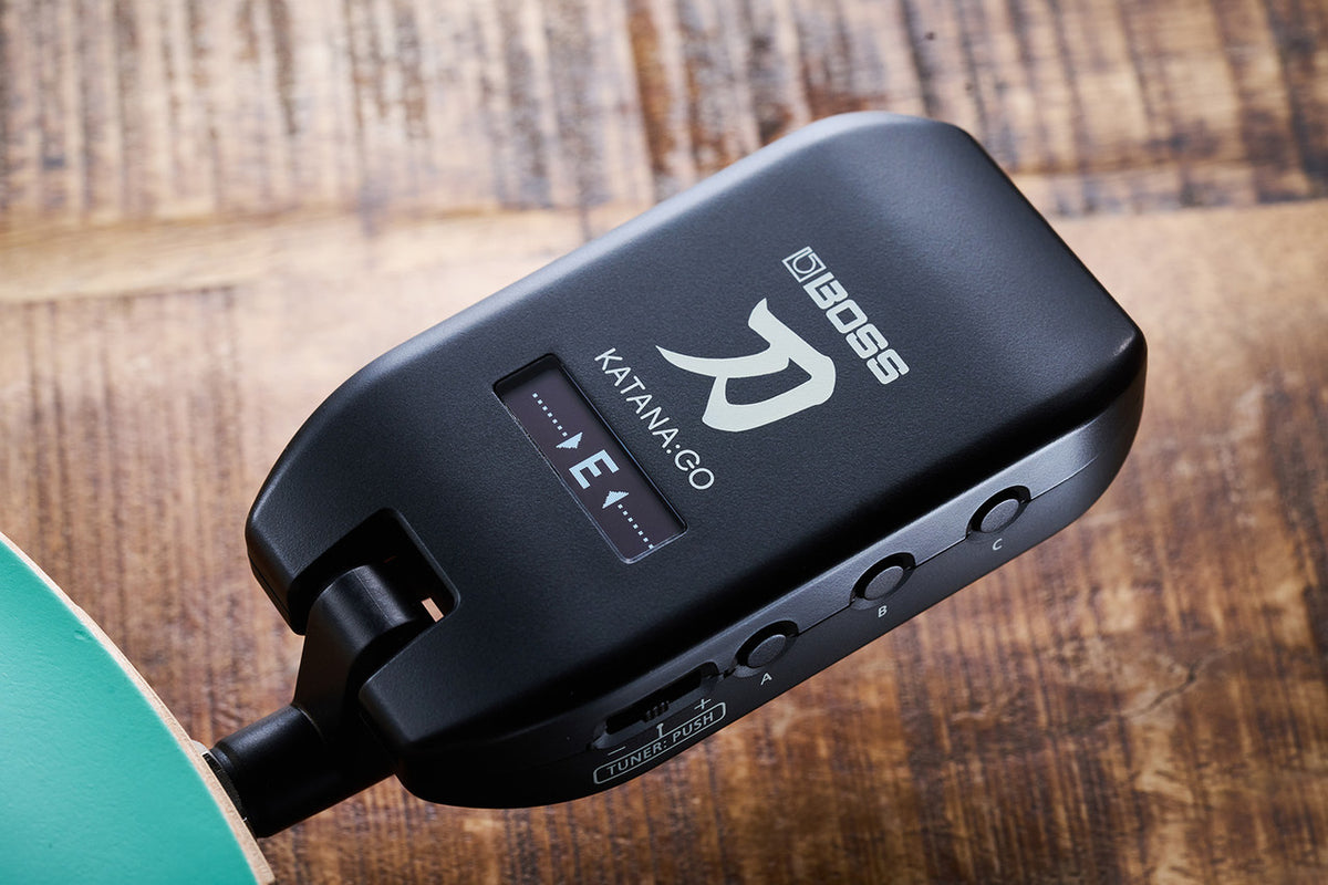 Boss Katana GO (KTNGO2) plugged into an electric guitar with the built-in tuner showing an in-tune low E on the OLED display