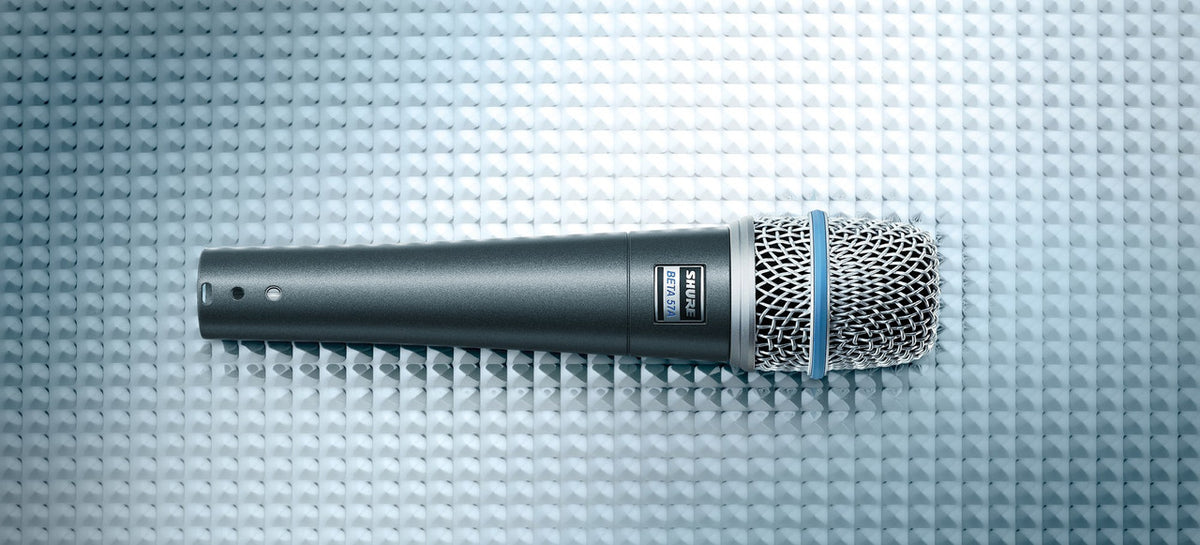 Shure Beta 57A dynamic microphone lying on a textured studio surface
