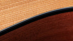 Close detail of the white purfling line between black binding and spruce grain